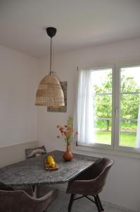 a dining room table with chairs and a window at Auszeitloge in Nottwil