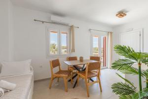 a dining room with a table and chairs and a couch at Casa Philippi Suites in Mikonos