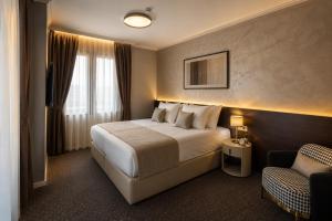 a hotel room with a bed and a chair at Nobel West Hotel in Belgrade +44 photos