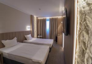 a hotel room with two beds and a window at Aqua Hotel in Varna City