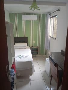 a small room with a bed and a table at Hotel Maciel in Ponta Grossa