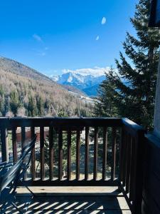 a wooden balcony with a view of the mountains at ComeCasa La Magdeleine 2BDR APT in La Magdeleine