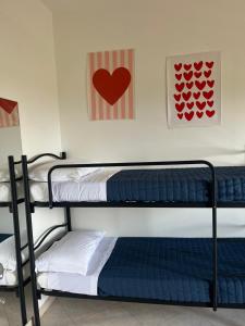 two bunk beds in a room with a heart on the wall at Una Piscina sul Mare Apartment in Milazzo +20 photos