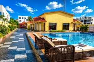 a resort with a swimming pool and chairs next to a building at Aryans Sea Sight Resort Mandarmani in Mandarmoni