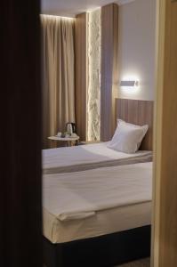 a bedroom with a large bed with white sheets at Aqua Hotel in Varna City