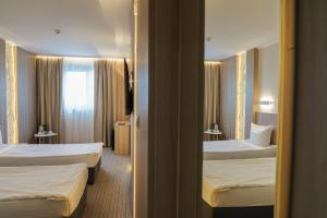 a hotel room with two beds and a window at Aqua Hotel in Varna City