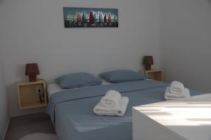 a bedroom with two beds with towels on them at Apartman Mala Artica in Drage
