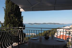 a table on a balcony with a view of the water at Apartman Mala Artica in Drage