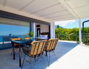 a patio with a table and chairs on a balcony at PNOẼ Luxury Apartments in Lourdata
