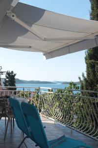 a patio with blue chairs and an umbrella at Apartman Mala Artica in Drage