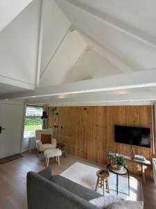 a living room with a couch and a tv at Vakantiewoning Asteri's Home in Simpelveld