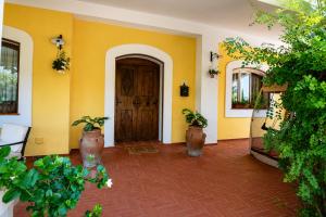 a room with yellow walls and a door with potted plants at Amunì da Vita e Pietro in Carini