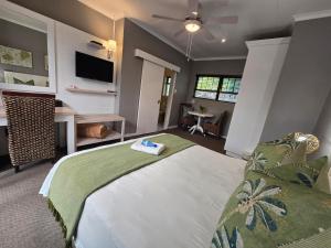 a bedroom with a bed and a flat screen tv at Bayside Guesthouse in Port Elizabeth