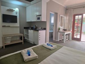 a bedroom with a large bed with towels on it at Bayside Guesthouse in Port Elizabeth