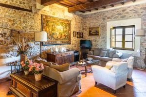 a living room with couches and chairs and a television at Agriturismo Morisfarms - Santa Laura in Cura Nuova