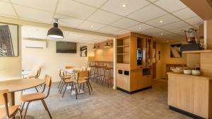 a kitchen and dining room with a table and chairs at Premiere Classe Versailles - Saint Cyr L'ecole in Saint-Cyr-lʼÉcole