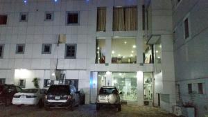 two cars parked in front of a building at night at Paris Suites in Festac Town
