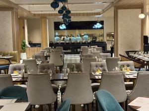 a restaurant with tables and chairs and a bar at Belle Vue Stays in Jaipur