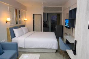 a bedroom with a large white bed and a tv at Belle Vue Stays in Jaipur