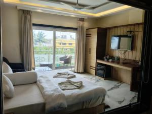 a hotel room with a bed and a television at Aryans Sea Sight Resort Mandarmani in Mandarmoni