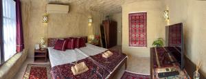 a bedroom with a bed with red pillows at Sirocave barlang apartmanok in Sirok