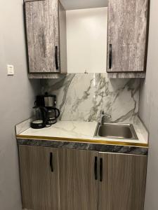 a kitchen with wooden cabinets and a sink at فندق كلاسيك in Aqaba +12 photos