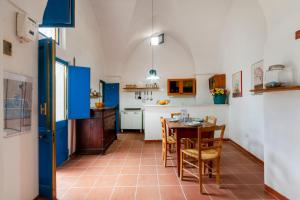 a kitchen with blue cabinets and a table and chairs at GuestHost - Casa Paola in Cannole