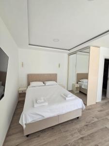 a white bedroom with a large bed and a mirror at Luxury Studio Apartment with Sea View & Heated Pool in Kotor +17 photos