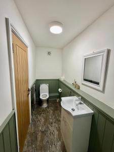 a bathroom with a white sink and a toilet at The Sycamore Inn in Birch Vale