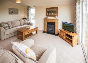a living room with a couch and a television at Holderness Country Park in Tunstall +18 photos