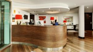 a lobby with a wooden counter with red lamps at Sercotel Coliseo in Bilbao