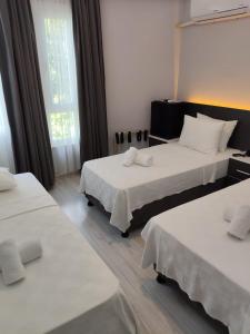 a hotel room with two beds and a window at Ayvalık Denizyıldızı Otel in Ayvalık