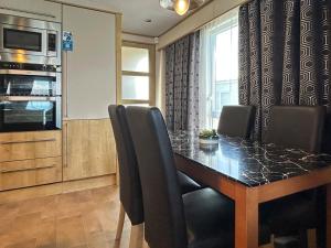 a dining room table with black chairs and a kitchen at Millars Caravan in Ayr
