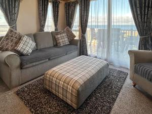 a living room with a couch and a large window at Millars Caravan in Ayr