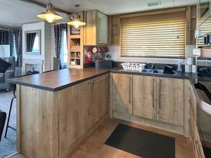 a kitchen with wooden cabinets and a large island at Millars Caravan in Ayr +11 photos