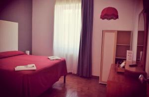 1 dormitorio con cama roja y espejo en Hotel Piccola Firenze, en Firenzuola