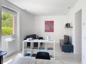 a living room with a white table and a tv at Apartment Titti - GLA133 by Interhome in Gera Lario +30 photos
