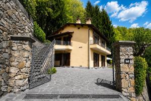 a house with a stone wall and a gate at Villa Marisa in Stazzema