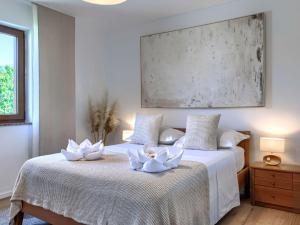 a bedroom with two white lilies on a bed at Holiday Home Sara by Interhome in Tar
