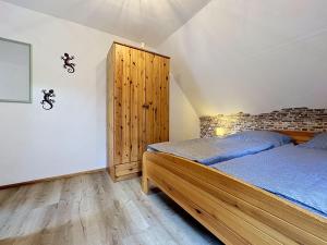 a bedroom with two beds and a wooden cabinet at Apartment Eifelhome One nahe Nürburgring by Interhome in Fuchshofen
