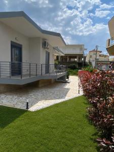 a house with a balcony and a grass yard at Soro Rooms in Kanali