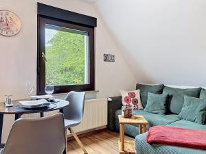 a living room with a green couch and a table at Apartment Eifelhome Two nahe Nürburgring by Interhome in Fuchshofen