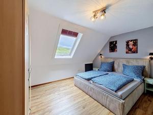 a bedroom with a bed and a window at Apartment Eifelhome Two nahe Nürburgring by Interhome in Fuchshofen