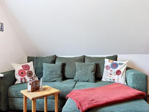 a living room with a green couch with pillows at Apartment Eifelhome Two nahe Nürburgring by Interhome in Fuchshofen
