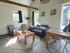a living room with a couch and a table at Holiday Home Zeeuwse Cottage Wemeldinge-1 by Interhome in Wemeldinge