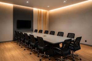 a conference room with a long table and black chairs at Slaviero Hotel Ponta Grossa in Ponta Grossa