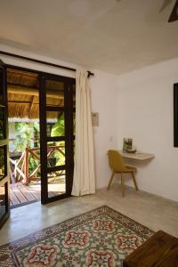 a room with a table and a chair and a rug at Kin Ha Tulum Hotel in Tulum