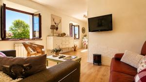 a living room with a couch and a tv at La Venta de Pedro in Ribadesella