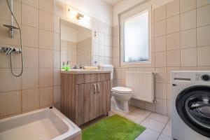 a bathroom with a sink toilet and a washing machine at Panoráma Vendégház Bükkösd in Bükkösd +27 photos