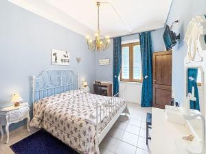 a blue bedroom with a bed and a chandelier at Holiday Home Il Cavaliere by Interhome in Castellero
